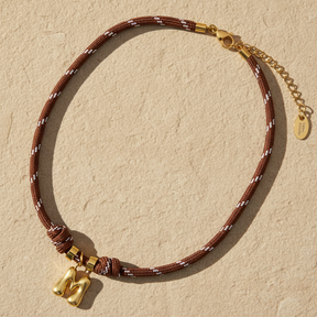 Collar de cuerda con letras burbuja doradas